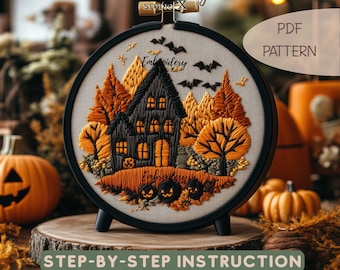 May include: A round black embroidery hoop containing a fabric panel with a stitched scene of a dark house, orange and yellow trees, and three jack-o'-lanterns. The design includes black bats, the text Embroidery Studio X, and PDF PATTERN.