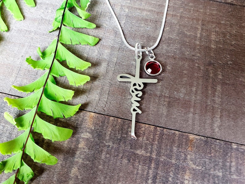 Steel Jesus cross necklace, with a ruby birthstone charm.