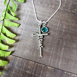 Steel Jesus cross necklace, with a blue zircon birthstone charm.