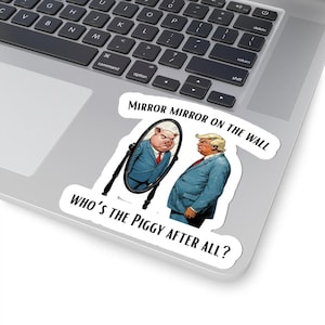 Puede incluir: Una pegatina blanca con el texto "MIRROR MIRROR ON THE WALL" y "WHO'S THE PIGGY AFTER ALL?". La pegatina presenta una ilustración de una persona mirándose en un espejo con un cerdo con traje.