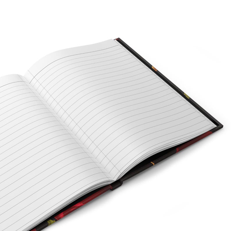 Puede incluir: Un cuaderno abierto con p&aacute;ginas rayadas y una cubierta negra con un dise&ntilde;o floral. La cubierta presenta flores rojas, amarillas y verdes.