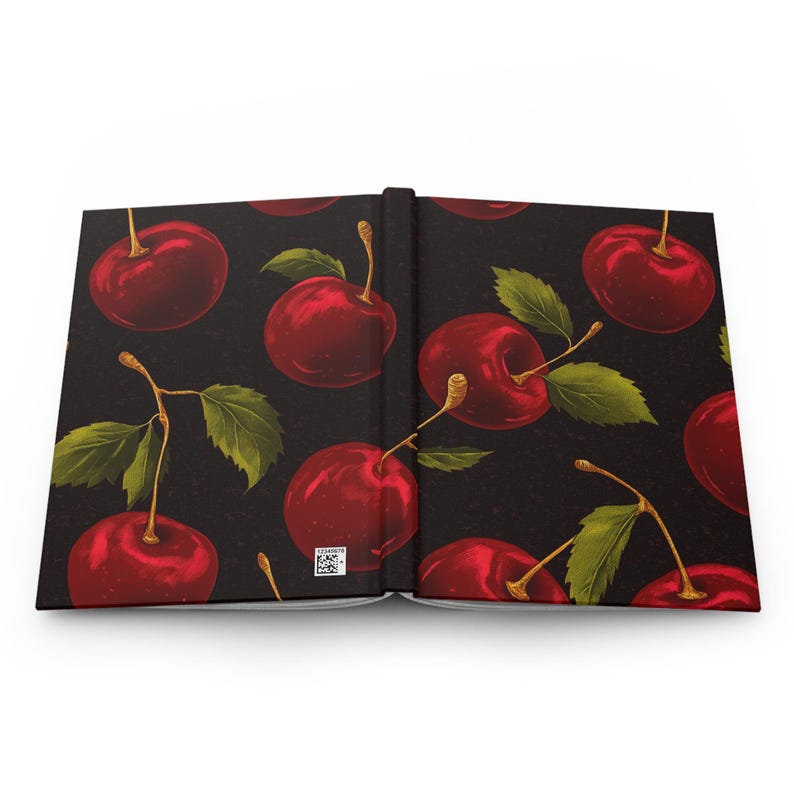 Puede incluir: Un libro abierto con fondo negro y un patr&oacute;n repetido de cerezas rojas. Las cerezas est&aacute;n dibujadas en un estilo realista con hojas y tallos verdes.