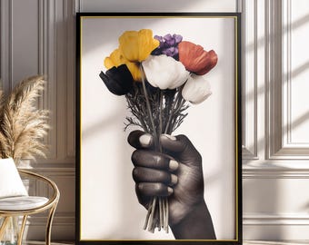 Può includere: Una stampa artistica da parete incorniciata che presenta un'illustrazione in bianco e nero di una mano che tiene un bouquet di fiori vivaci. I fiori includono petali gialli, bianchi, rossi e viola, in contrasto con la mano monocromatica.