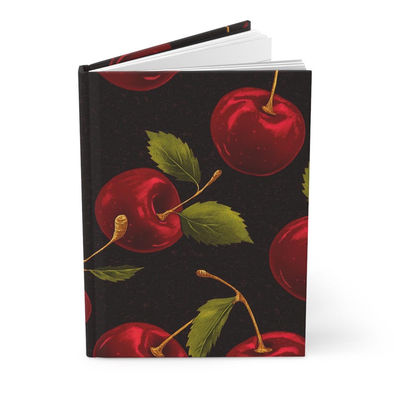 Puede incluir: Un cuaderno negro con un patr&oacute;n repetido de cerezas rojas y hojas verdes.