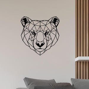 May include: Geometric black bear head silhouette wall art. The bear's face is made up of triangles and lines, creating a modern and minimalist design.