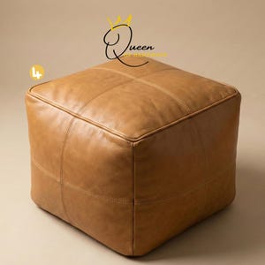 May include: A square, light brown leather ottoman with stitched detailing. The ottoman has a cube shape and is placed on a neutral background. The text "Queen of Handmade" is visible in the upper right corner.