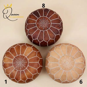 Könnte beinhalten: Drei runde Leder-Puffs in Braun- und Beigetönen. Jeder Hocker hat ein geometrisches Muster mit weißen Nähten und ein zentrales Schneeflocken-Design. Die Puffs sind mit den Nummern 1, 6 und 8 versehen.