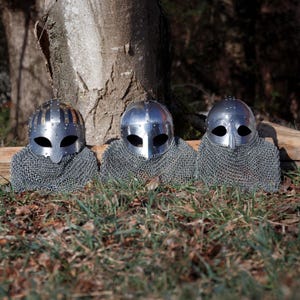 Displaying 3 Gjermundbu helmet with brass accents & chainmail, medieval Viking chainmail helmet for Viking cosplay, LARP costume, Renaissance faire outfit, Viking decor, Viking accessories & medieval cosplay reenactment display.