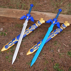 May include: Two toy swords with blue and gold scabbards. One sword is silver, the other is light blue. The hilts are blue with gold accents. The scabbards are blue with gold designs.