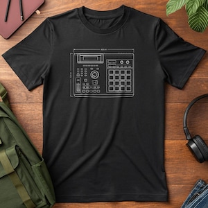 Puede incluir: Camiseta negra con un esquema blanco de una caja de ritmos vintage. El diseño incluye dimensiones de 40,1 cm de ancho y 12,8 cm de alto. La camiseta tiene cuello redondo y mangas cortas, ideal para los amantes de la música.