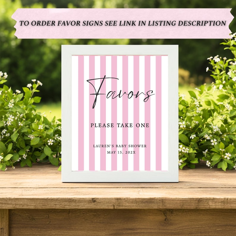 May include: A white framed sign featuring a pink and white vertical striped background. The text reads "Favors", "PLEASE TAKE ONE", "LAUREN'S BABY SHOWER", and "MAY 15, 202X". The top banner text reads "TO ORDER FAVOR SIGNS SEE LINK IN LISTING DESCRIPTION".
