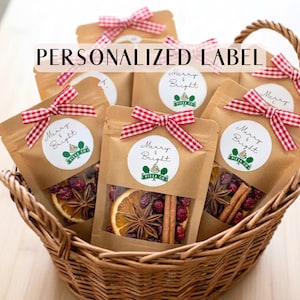 May include: A brown paper pouch filled with dried orange slices, star anise, cinnamon sticks, and cranberries. Each pouch features a white circular label with the text Merry & Bright and a red and white checkered ribbon bow.
