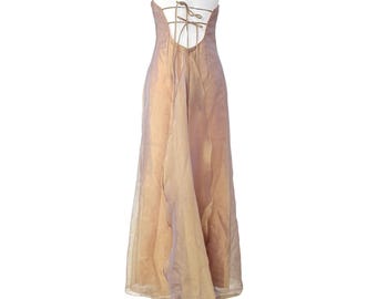 May include: A strapless, floor-length gown in a shimmering champagne color. The back features a low cut with a lace-up design. The flowing skirt has a train. The dress is displayed on a mannequin.