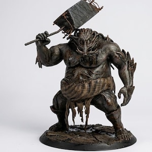 May include: A detailed, brown fantasy figurine of a muscular, monstrous figure holding a large, square weapon above its head. The figure has a grotesque face and is posed on a circular base, with intricate details and textures.