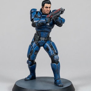 May include: A detailed figurine of a man in a blue and black armored suit, holding a red and black weapon. The figure is standing on a gray circular base. The armor has intricate details and highlights. The figure has short black hair and a serious expression.