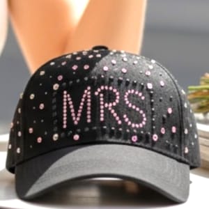 Peut inclure: Casquette de baseball noire avec le mot "MRS" en strass roses. La casquette est ornée de petits strass. La visière est gris foncé. Un accessoire élégant.