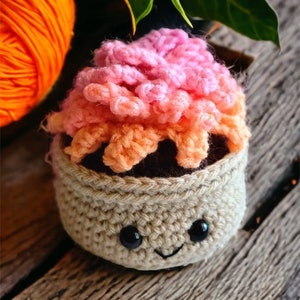 May include: A crocheted amigurumi sushi roll with a pink and orange filling, brown seaweed, and a smiling face.