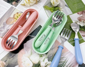 Può includere: Tre set di posate per bambini in rosa, verde e blu. Ogni set include una forchetta, un cucchiaio e un astuccio. Le posate hanno teste in acciaio inossidabile e manici colorati. Il set verde ha il nome "Alexia".