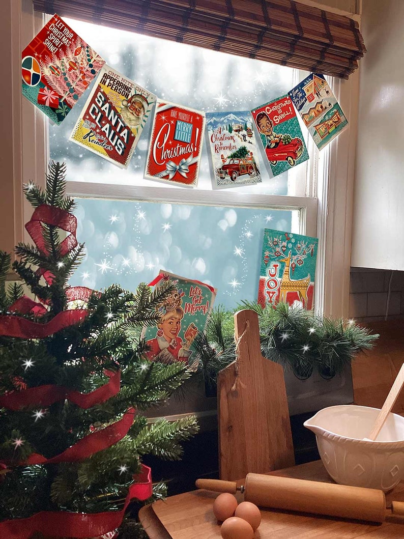 Pu&ograve; includere: Una collezione di cartoline di Natale vintage appese a una finestra con un piccolo albero di Natale e utensili da forno su un bancone di legno sottostante. Le cartoline presentano immagini e testi festivi come "Let Your Christmas Spirit Shine!" e "Merry Christmas!"