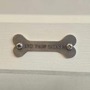 May include: A white ceramic mug with a black handle and the text "But First, Coffee" in a bold, black font. The mug is sitting on a wooden surface. The mug is approximately 4 inches tall.