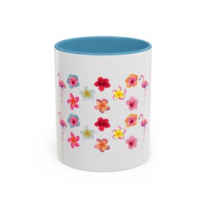 Peut inclure: Mug en céramique blanche avec intérieur bleu, décoré de fleurs colorées et d'illustrations de flamants roses. Le mug est conçu pour les boissons chaudes ou froides et convient à la maison ou au bureau.