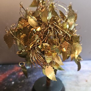 May include: A gold wire tree sculpture with gold leaf leaves on a black base.