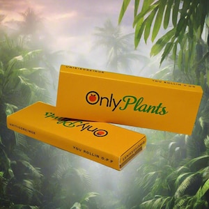 May include: Two yellow boxes with the text "Only Plants" and "You Rollin O.P.P" printed on them. The boxes are stacked on top of each other and are set against a blurry background of green foliage.