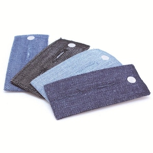 May include: A collection of four denim fabric extenders in various shades of blue and black. Each extender has a button closure and a stitched buttonhole, designed to add extra room to waistbands.