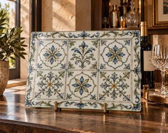 Tabla de cortar de vidrio con azulejos ornamentales, diseño botánico azul y verde.