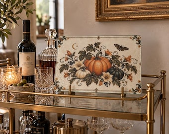 Tabla de cortar de cristal con diseño de calabaza otoñal y motivos botánicos vintage.