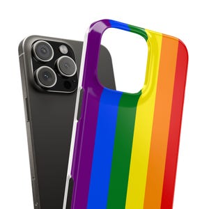 Puede incluir: Un smartphone con una funda negra y una funda para teléfono a rayas de arcoíris. La funda de arcoíris presenta rayas verticales en los colores de la bandera del orgullo: morado, azul, verde, amarillo, naranja y rojo. La funda del teléfono es de material brillante.