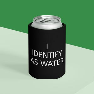 May include: A black can cooler with the text "I IDENTIFY AS WATER" in white. The cooler is holding a silver can. The background is a gradient of green and white.