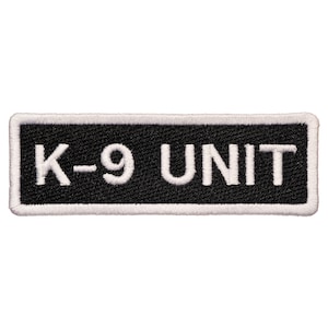 May include: White embroidered text on a black rectangular patch that reads "K-9 UNIT".