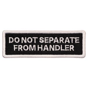 May include: White embroidered text on a black rectangular patch that reads "DO NOT SEPARATE FROM HANDLER".