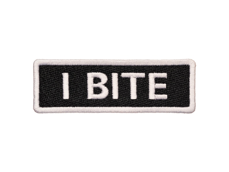 Pu&ograve; includere: Toppa ricamata in bianco e nero con testo bianco che recita "I BITE" su sfondo nero.