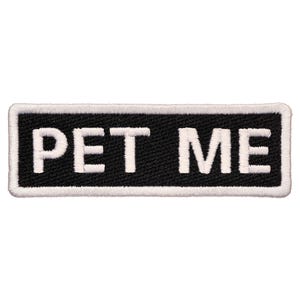 May include: Black and white embroidered patch with white text that reads "PET ME" on a black background.