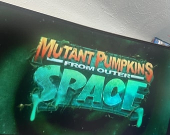 Könnte beinhalten: Der Titel "MUTANT PUMPKINS FROM OUTER SPACE" wird in einem auffälligen Design präsentiert. Der Text ist vor einem dunkelgrünen Hintergrund mit einem Tropfeffekt platziert, was eine Science-Fiction- oder Horrorfilm-Atmosphäre erzeugt. Ein Urheberrechtshinweis ist ebenfalls sichtbar.