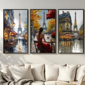May include: Triptych of framed art prints depicting Parisian street scenes. The artwork features the Eiffel Tower, cafes, and figures in a rainy, impressionistic style. The color palette includes warm tones of red, orange, and yellow, contrasted with cool blues and grays.