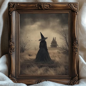 May include: A framed print depicting a witch in a black dress and hat, set in a field with a haunted house in the background. The artwork is in a decorative brown frame, with a vintage feel. The scene is set under a cloudy sky.