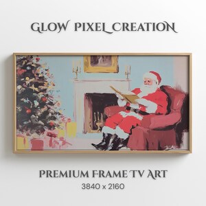 Op de afbeelding: Een ingelijste print van de Kerstman die een boek leest in een rode fauteuil, met een kerstboom en een open haard op de achtergrond. De print heeft een licht houten frame. De tekst luidt "GLOW PIXEL CREATION" en "PREMIUM FRAME TV ART".