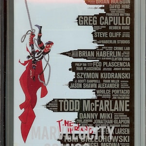 May include: A CGC graded 9.4 Spawn #312 comic book in a plastic slab. The cover features a black and red character hanging from a chain on the left, with a list of names in black text on a white background, including Todd McFarlane.