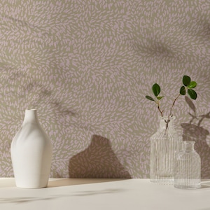 Könnte beinhalten: Drei Glasvasen mit strukturierter Oberfläche, zwei sind klar und eine ist weiß. Die Vasen stehen auf einer hellbraunen Oberfläche vor einer Wand mit einem abstrakten Muster in Rosa und Beige.