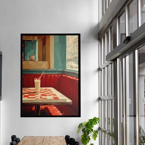 Puede incluir: Impresión enmarcada de una escena de restaurante. La obra presenta una cabina roja, una mesa a cuadros y un batido con pajita. El fondo muestra una vista de la calle, todo en un estilo retro.