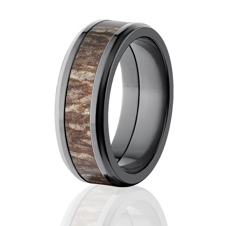 May include: A black and brown wedding band with a wood inlay. The band has a beveled edge and a polished finish.