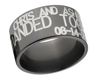 May include: A dark gray ring with engraved white text. The text reads "CHRIS AND ASHLEY BANDED TOGETHER 08-14-20". The ring has a smooth, reflective surface and a wide band design. A personalized piece of jewelry.