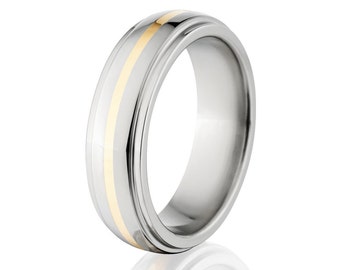 May include: A silver wedding band with a gold inlay. The band has a rounded profile and a smooth finish.