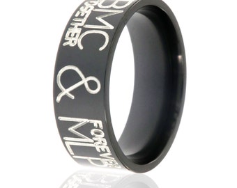 May include: Black titanium ring with the inscription "BMC & MILP FOREVER TOGETHER" engraved in silver lettering.