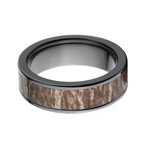 May include: A black ceramic ring with a brown wood inlay. The ring has a polished finish and a wide band.