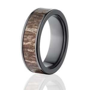 May include: A black ceramic ring with a brown wood inlay. The ring has a polished finish and a beveled edge.