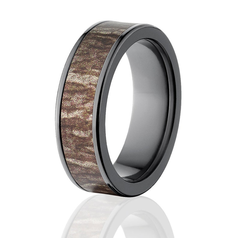 May include: A black ceramic ring with a brown wood inlay. The ring has a polished finish and a beveled edge.